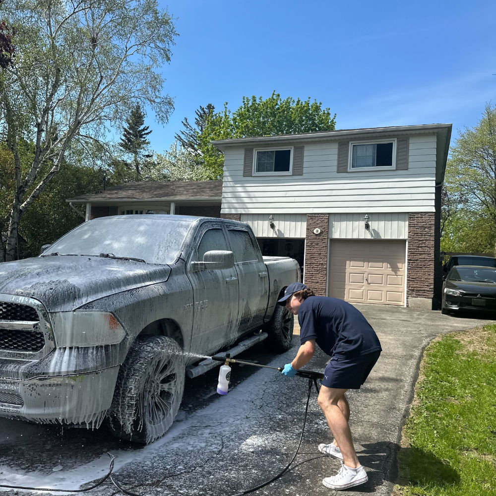 A car detailer washing the exterior of a truck