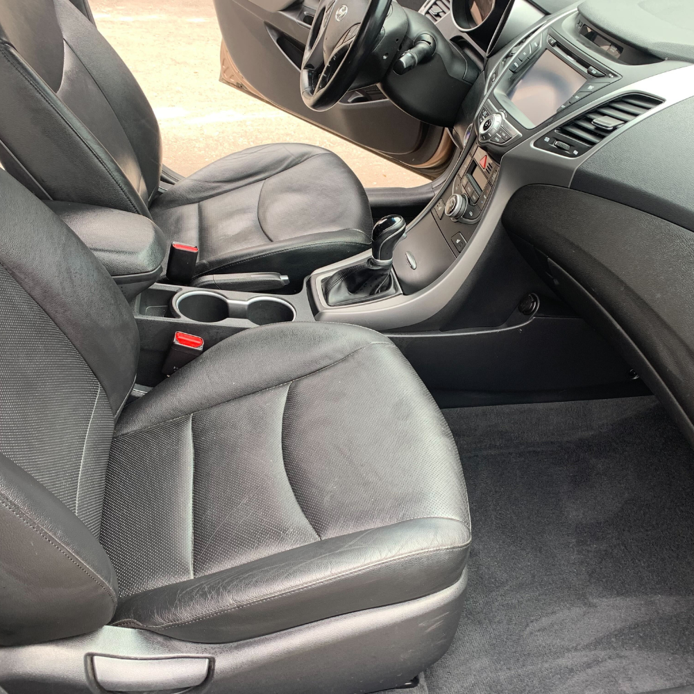 The front seat of a car that just had its leather seats cleaned.